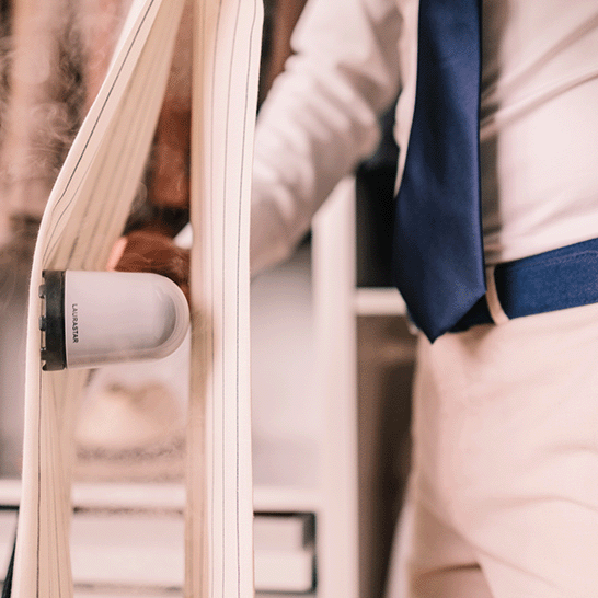 A Man refreshing his suit trouser with the Laurastar IZZI steamer